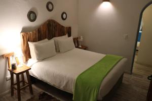 a bedroom with a large bed with a green blanket at Casa Hotel Santa Helena Boutique in Villa de Leyva