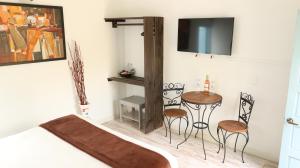 a bedroom with a bed and a table and chairs at HOTEL BOUTIQUE Santa Helena in Villa de Leyva