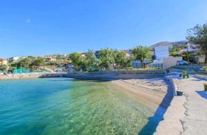 a beach with blue water and trees and buildings at Apartment Andrea in Miškovići