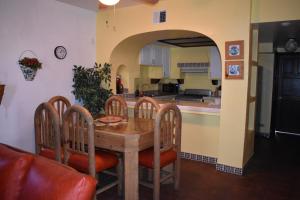 uma cozinha e sala de jantar com uma mesa de madeira e cadeiras em La Paloma Beach&Tennis Resort em Rosarito