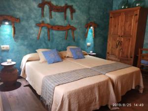 a bedroom with two beds with blue walls at Casa Rural La Charolesa in Aguilera +33 photos