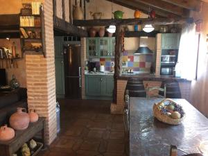a kitchen with a table in the middle of it at Casa Rural La Charolesa in Aguilera