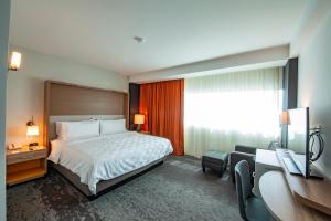 a hotel room with a bed and a desk at Holiday Inn & Suites - Merida La Isla, an IHG Hotel in Mérida