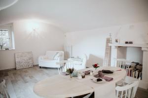 biała jadalnia ze stołem i krzesłami w obiekcie Guest House Al Devesio w mieście Rifreddo