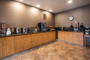 a kitchen with wooden cabinets and a clock on the wall at La Quinta by Wyndham Eugene in Eugene