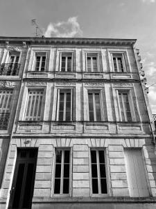 ein Schwarz-Weiß-Foto eines Gebäudes mit Fenstern in der Unterkunft Romance au coeur de Bordeaux / Jardin Public in Bordeaux