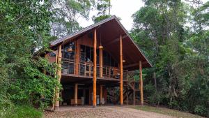 a wooden house in the middle of a forest at The Canopy Rainforest Treehouses & Wildlife Sanctuary in Tarzali