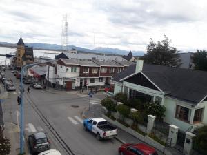 a city street with a blue truck parked in front of houses at Snow Rest in Ushuaia