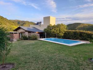a backyard with a swimming pool and a house at Casa El Drago in La Cumbre