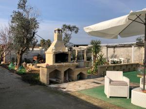 een stenen open haard met een stoel en een parasol bij Relais Regina Giulia in Gallipoli