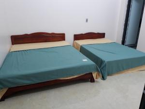 twee bedden naast elkaar in een kamer bij Homestay Hùng My in Ha Giang