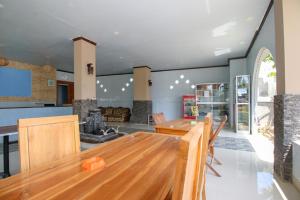 a dining room with a wooden table and chairs at Ridho Malik Hotel in Bumbang