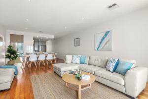 una sala de estar con un sofá y una mesa en Sea Star - Aldinga Beach - C21 SouthCoast Holidays, en Aldinga Beach