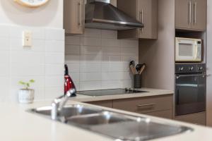 a kitchen with a sink and a microwave at Sea Star - Aldinga Beach - C21 SouthCoast Holidays in Aldinga Beach