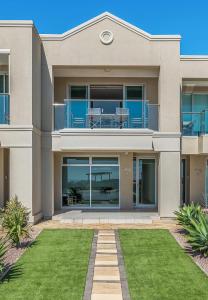 a house with a balcony and a lawn at Sea Star - Aldinga Beach - C21 SouthCoast Holidays in Aldinga Beach