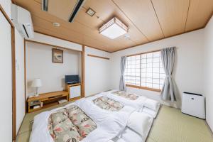 a bedroom with a bed and a window at Sunny Stone Hotel in Osaka