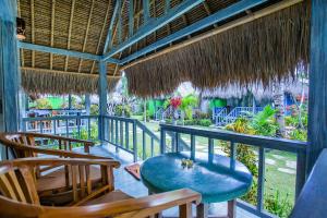 a balcony of a resort with chairs and tables at TS Hut Lembongan in Nusa Lembongan