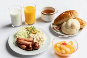 a table with two plates of food and two glasses of milk at Sunny Stone Hotel in Osaka