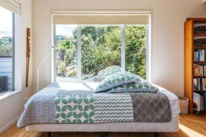 una camera con un letto e una grande finestra di Alison's Place - Onetangi Holiday Home a Onetangi