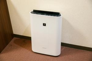 a white refrigerator with a cell phone on top at Sunny Stone Hotel in Osaka