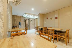 a dining room with wooden tables and chairs at Permata Inn in Medan
