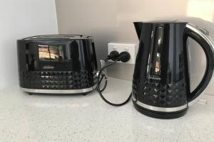 a toaster and a coffee maker on a counter at Mountain Mist Apartments in Bright