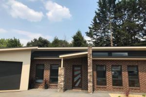 a brick house with a garage at Mountain Mist Apartments in Bright