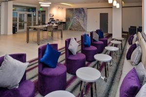 a row of purple chairs and tables in a room at Holiday Inn Express & Suites San Diego - Mission Valley, an IHG Hotel in San Diego