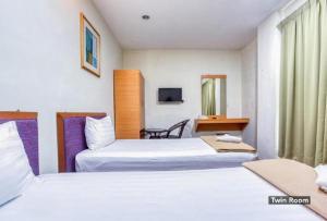 En eller flere senger på et rom på Hotel Sri Malim