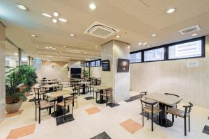 un restaurante con mesas y sillas en una cafetería en Sunny Stone Hotel, en Osaka