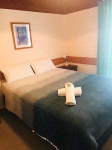a bedroom with a bed with two towels on it at Lighthouse Beach Holiday Village in Port Macquarie