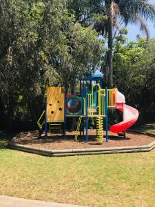 a playground with a slide in a park at Lighthouse Beach Holiday Village in Port Macquarie