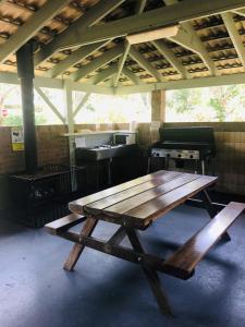 a wooden picnic table sitting inside of a building at Lighthouse Beach Holiday Village in Port Macquarie