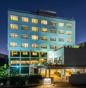 um grande edifício azul com muitas janelas à noite em The Pearl em Hassan