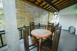 a room with a table and chairs on a balcony at Grand Casa in Kandy