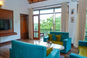 a living room with blue chairs and a table at The Grand Hanthana in Kandy