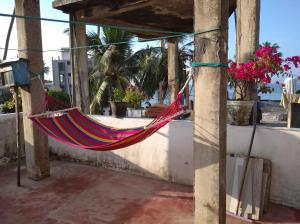 een hangmat hangend aan een veranda met de oceaan op de achtergrond bij Sun Ocean Inn Mirissa in Mirissa