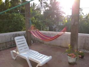 een hangmat en een stoel op een patio bij Sun Ocean Inn Mirissa in Mirissa