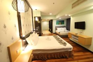 Habitación de hotel con cama y TV en Raintree Resort Suites, en Petaling Jaya