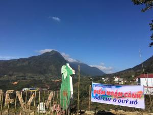 ein Schild auf einem Zaun mit einem Berg im Hintergrund in der Unterkunft Sapa Dao Homestay in Sa Pa