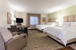 a hotel room with two beds and a desk at Candlewood Suites - Davenport by IHG in Davenport +17 photos