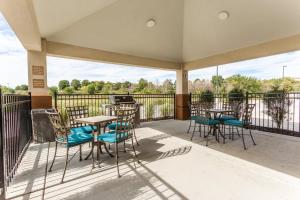 a balcony with tables and chairs and a grill at Candlewood Suites - Davenport by IHG in Davenport