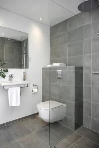 a bathroom with a shower and a toilet and a sink at HORISONT Hotel & Konference in Aarhus