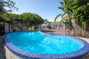 a large blue swimming pool in a yard at Kerikeri Court Motel in Kerikeri