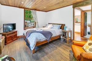 una camera da letto con un letto, una TV e un divano di Blackwood Park Cottages Mole Creek a Mole Creek