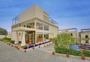 a large building with a pool in front of it at The Kumbha Residency by Trulyy - A Luxury Resort and Spa in Kumbhalgarh