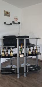 Una mesa con botellas y dos sillas. en Ferienwohnungen Nahrstedt, en Waldeck