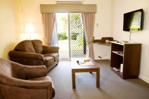 a living room with a couch and a chair and a table at Mercure Bunbury Sanctuary Golf Resort in Bunbury