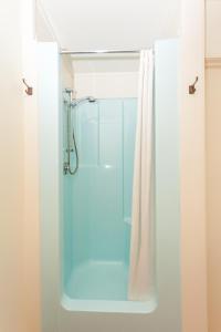 a bathroom with a shower with a glass door at Kerikeri Court Motel in Kerikeri