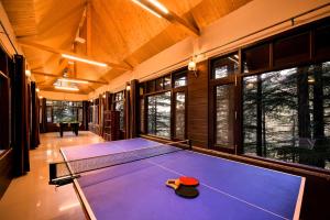 a ping pong table in a room with windows at Zostel Homes Mashobra (Shimla) in Mashobra
